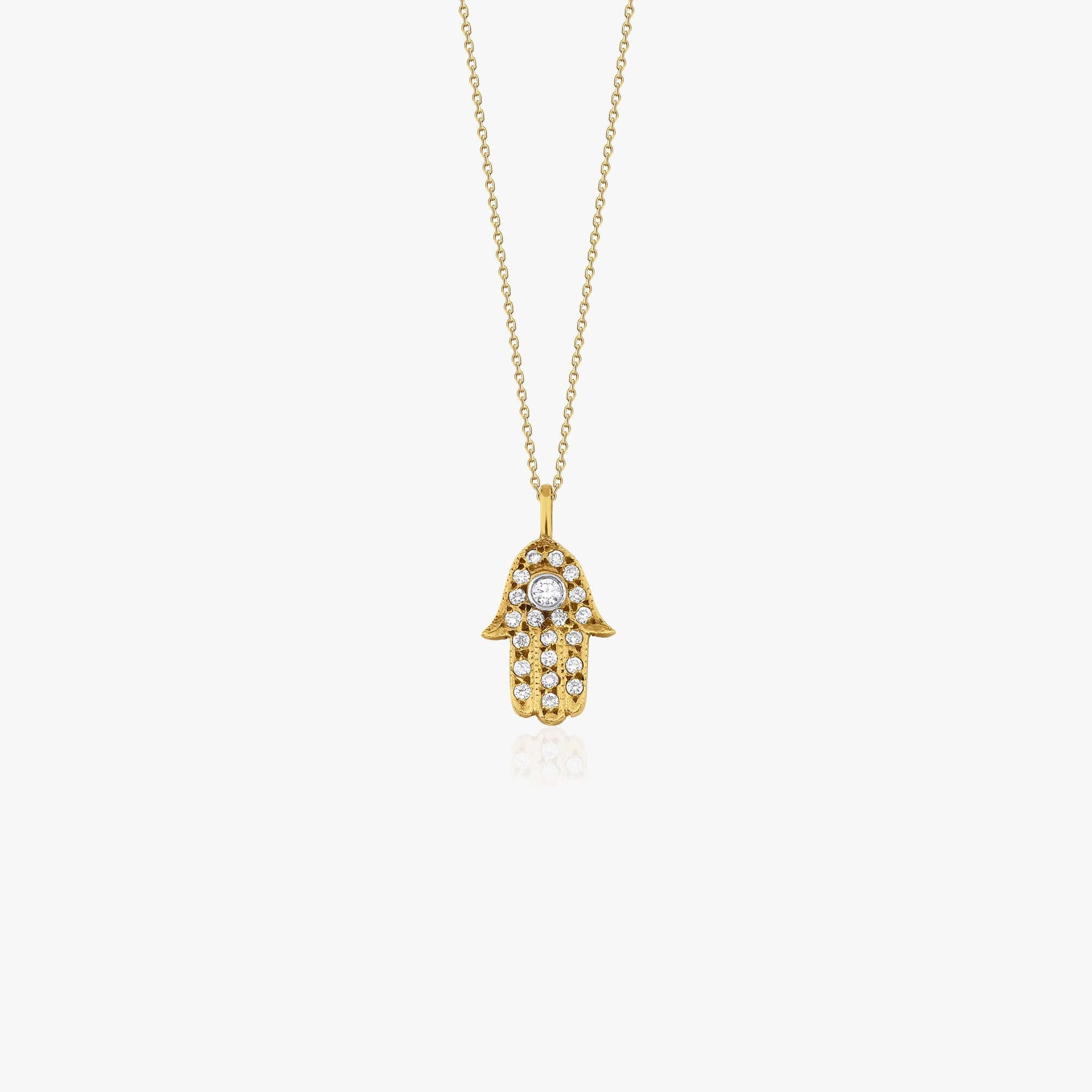 Gold necklace with a Hamsa hand pendant on a white background