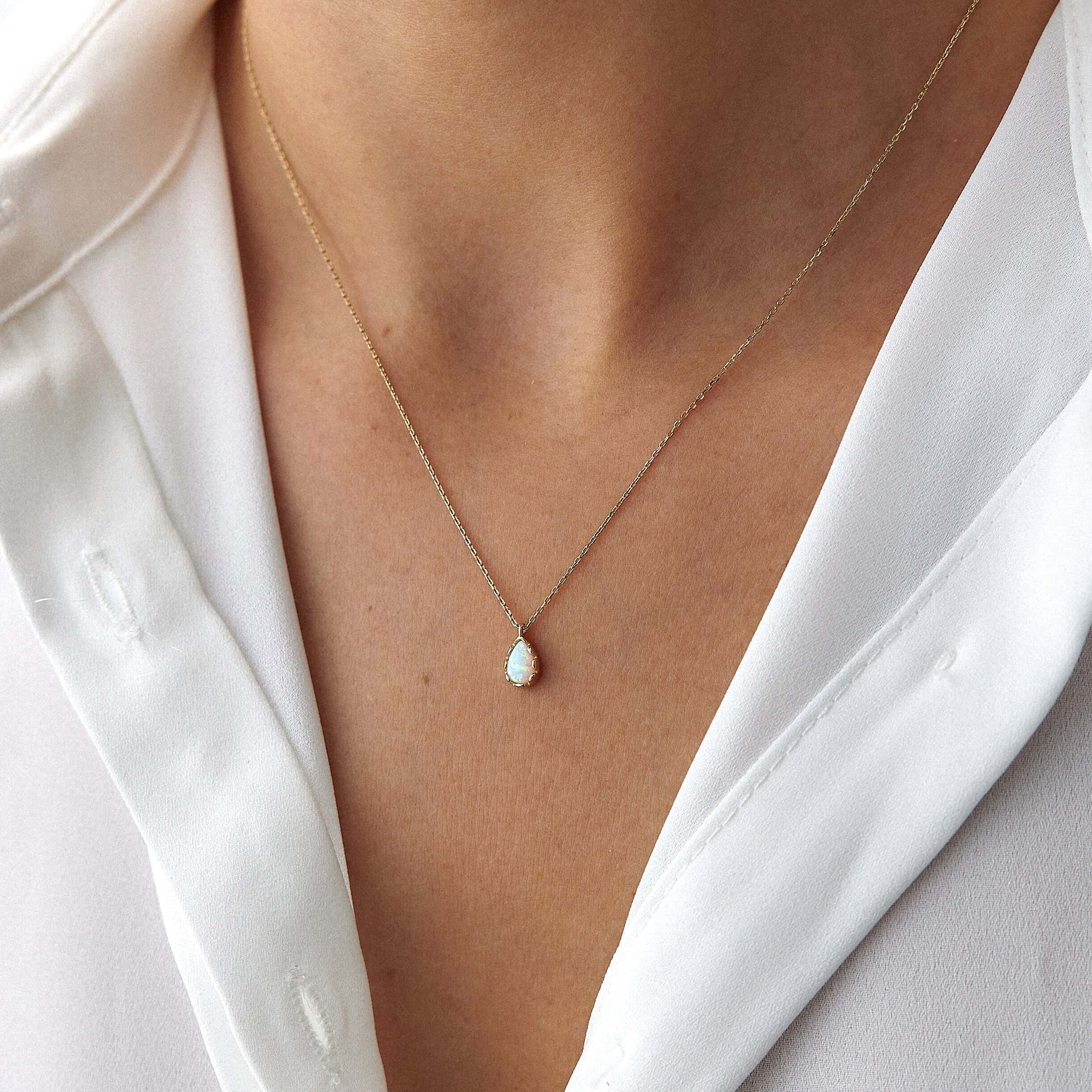 14 ayar sarı altın damla opal kolyeyi model takarken