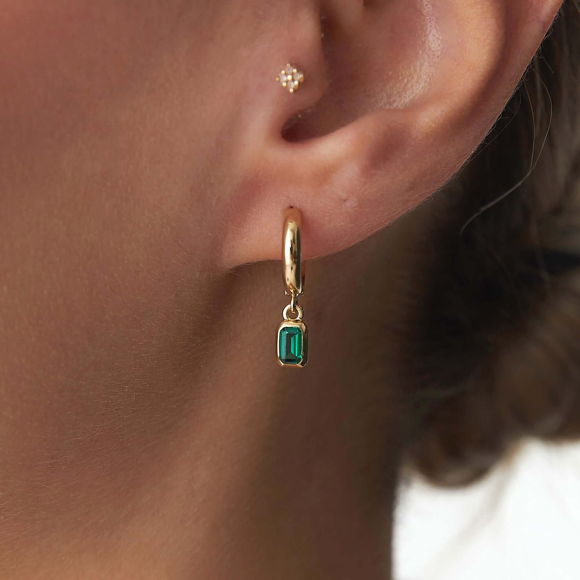 14 ayar sarı altın yeşil sallantılı halka küpe model üzerinde yakın açıdan