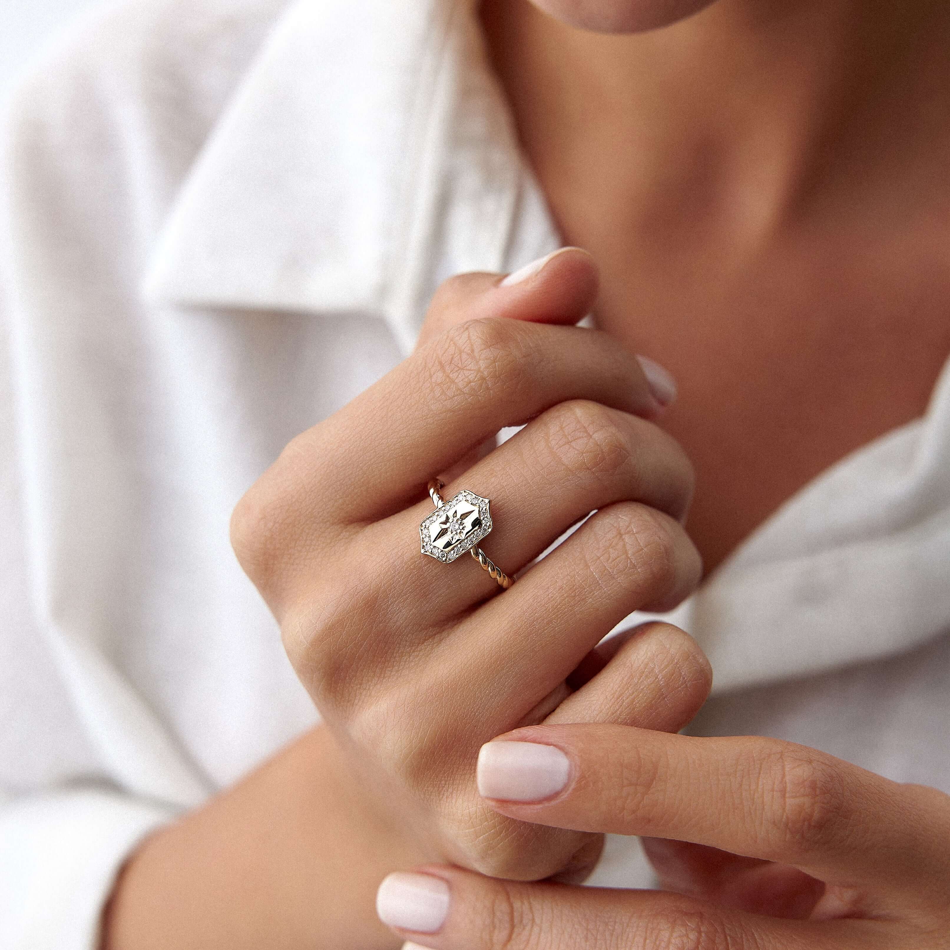 model parmağında pırlanta kuzey yıldızı kalkan tasarımlı bir yüzük takıyor