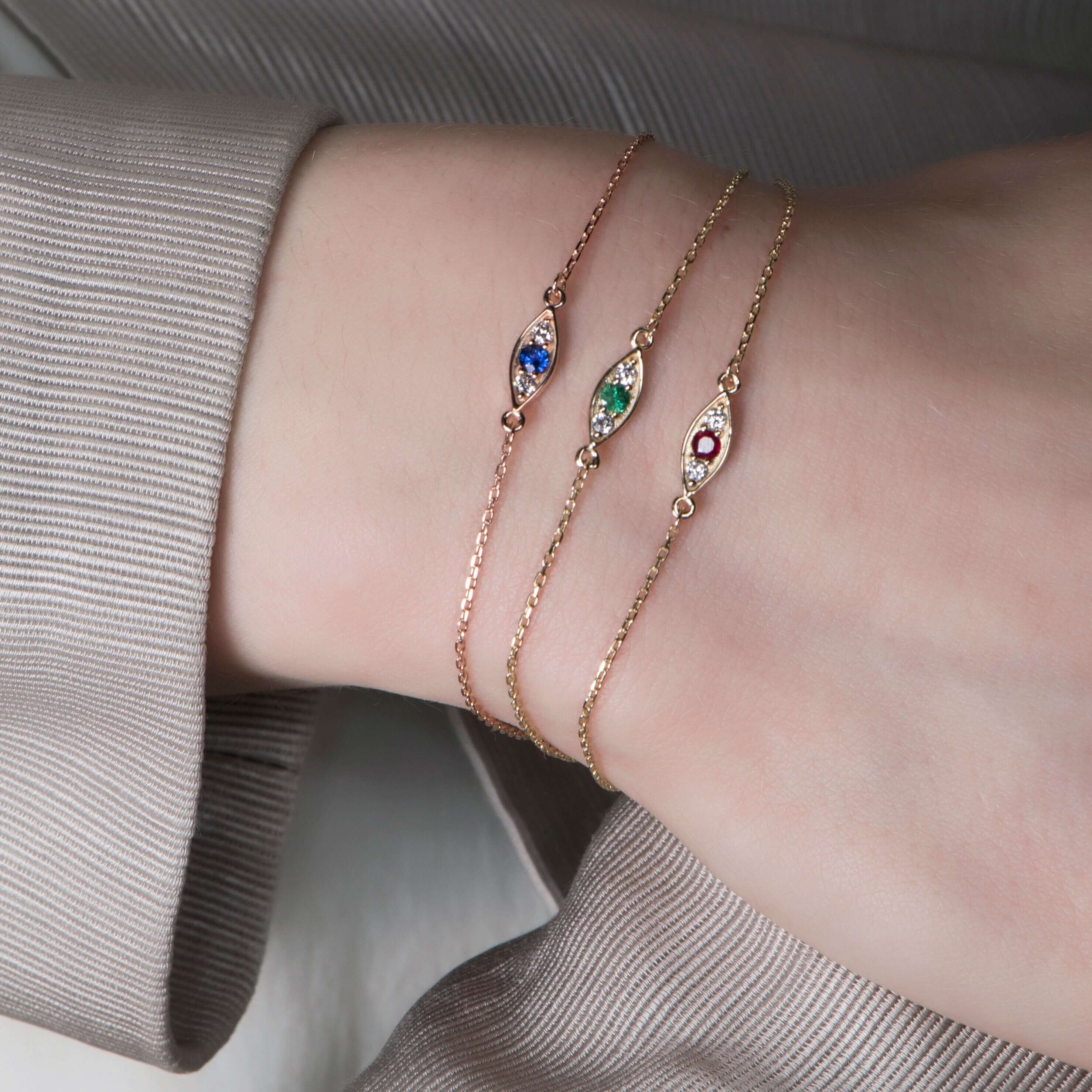 modelin bileğinde zümrüt, yakut ve safir 3 tane bileklik var